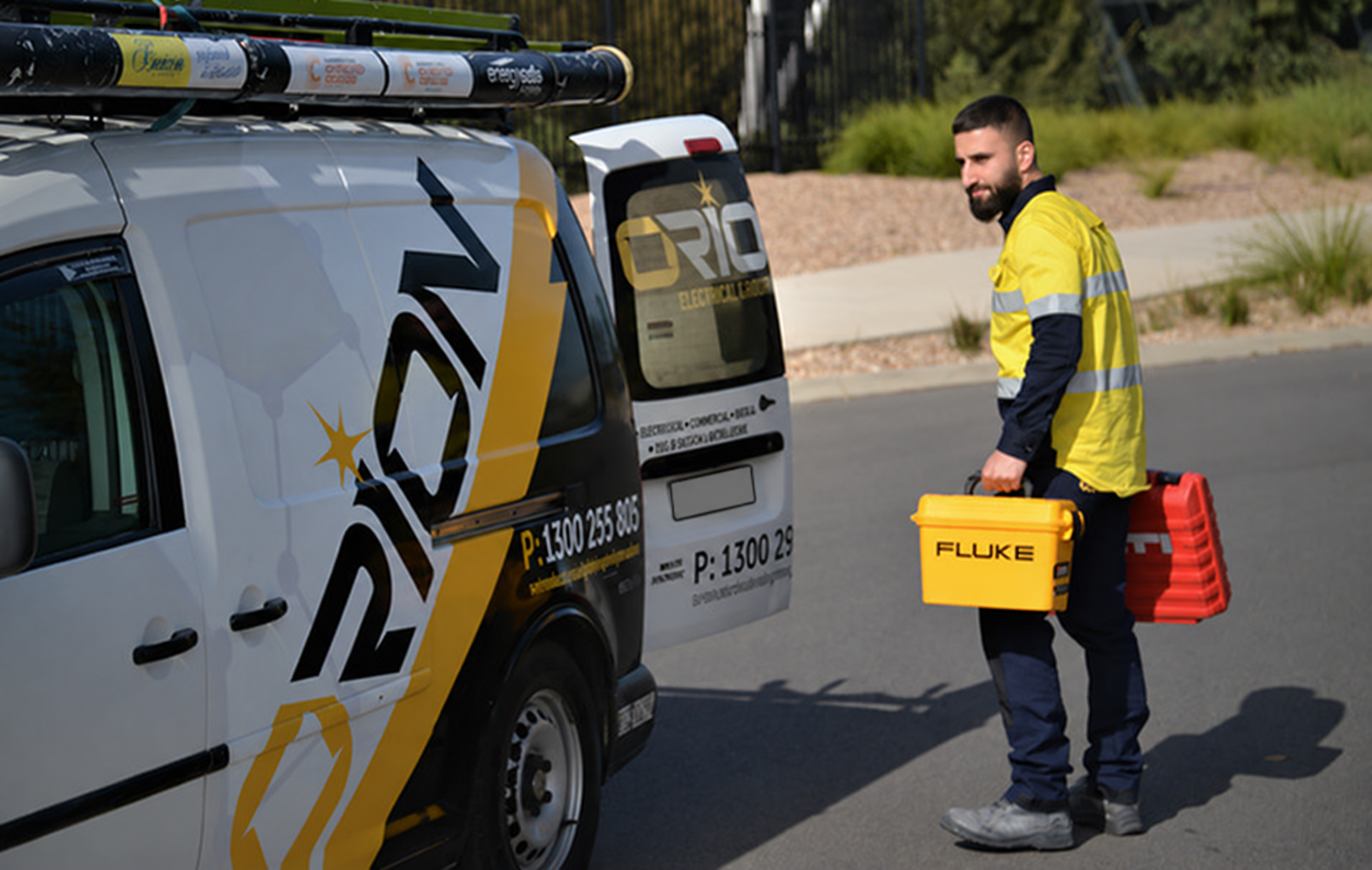 Orion electrician carrying tools beside the Orion service van